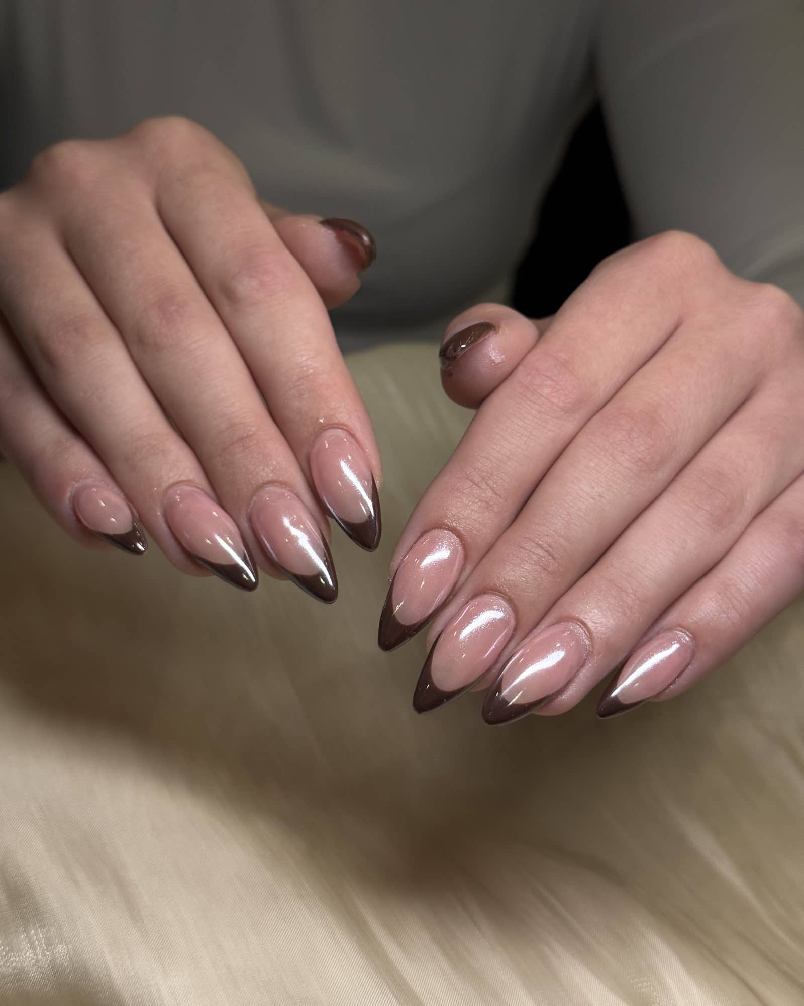 Glassy chocolate-brown French tips on long almond nails