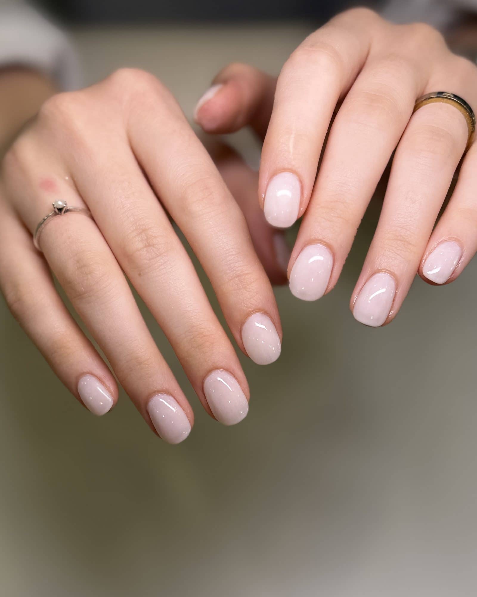 Short, clean nude nails with a sheer glossy shellac finish